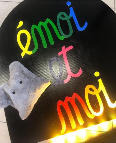 Texte coloré "émoi et moi" avec une peluche d'éléphant grise.